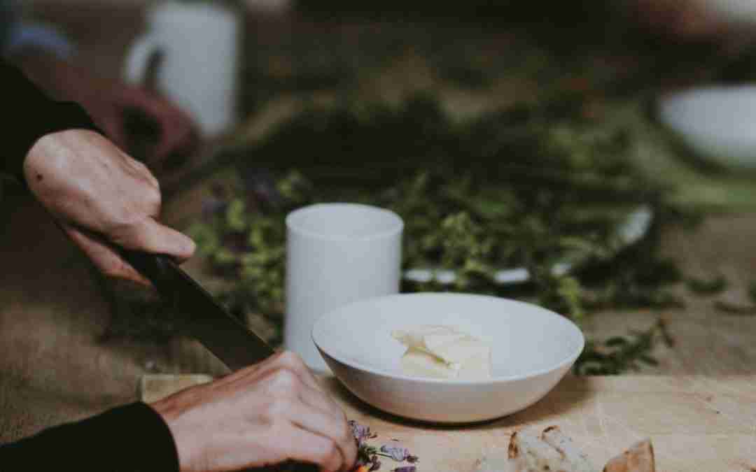 person chopping vegetable on brown wooden cutting board