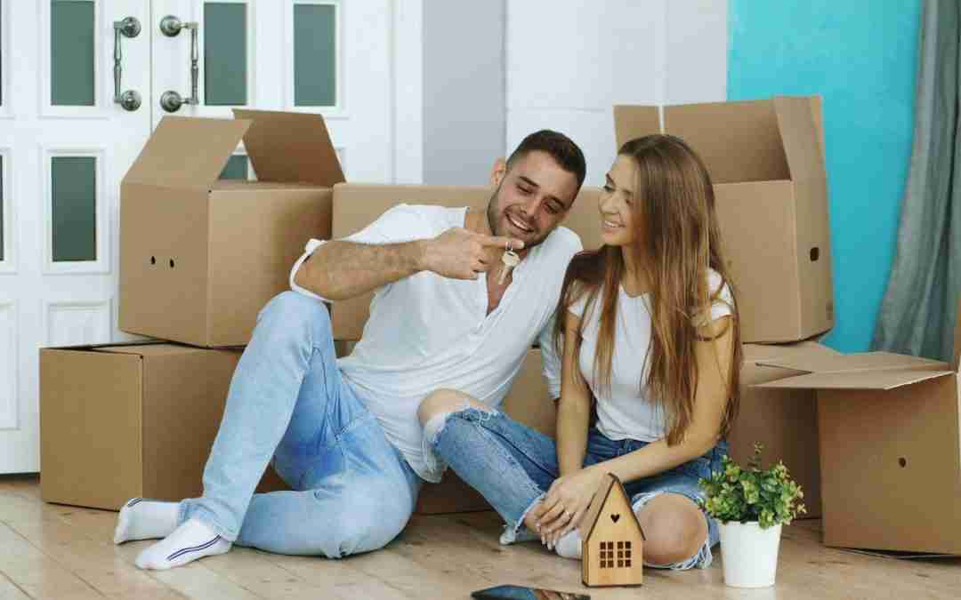 Couple sitting among moving boxes in new home