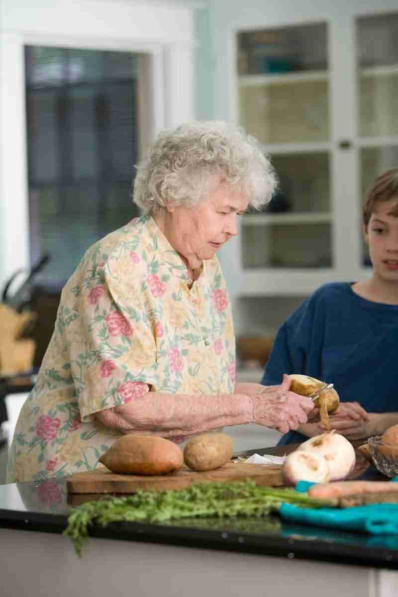 Wellbeing in the home woman in pink and white floral button up shirt holding brown wooden tray