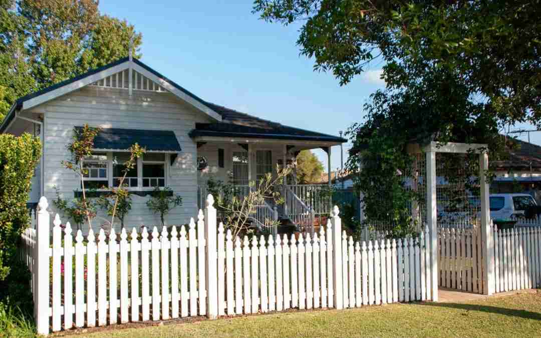 A white picket fence in front of a house